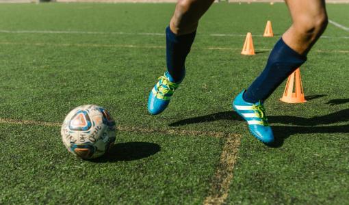 Player Skillfully Dribbling the Ball Across the Soccer Field